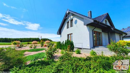 a white house with a black roof at Agrosielanka in Lipnica