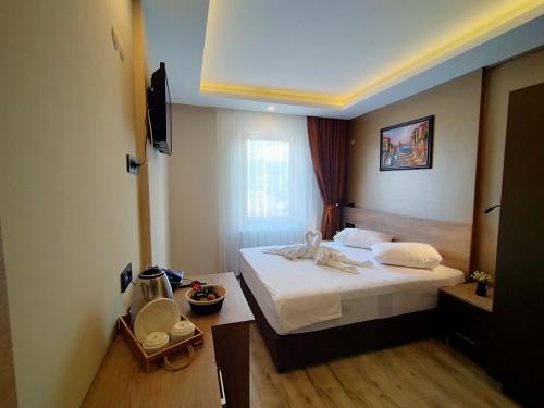 una camera d'albergo con un letto e una televisione di Palmiye Royale Palace a Edirne