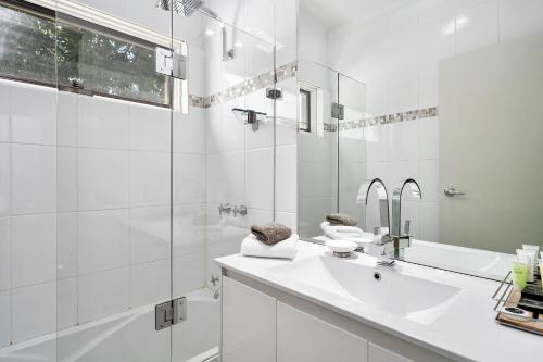 a white bathroom with a sink and a shower at Comfort Inn Coach & Bushmans in Seymour