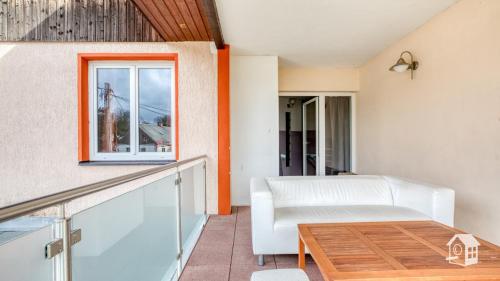 a living room with a white couch and a table at 4 Ferienwohnungen ab 1 bis 7 Schlafzimmer mit Sommerpool in Heinsdorfergrund