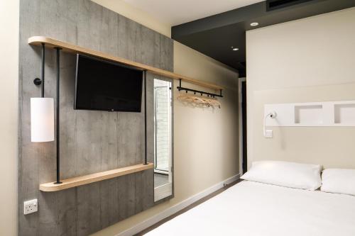 a bedroom with a bed and a tv on a wall at ibis Budget Sheffield Centre St Marys Gate in Sheffield