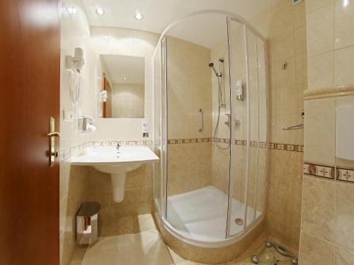 a bathroom with a shower and a sink at Kúpele Brusno - Kúpeľný hotel Poľana in Brusno