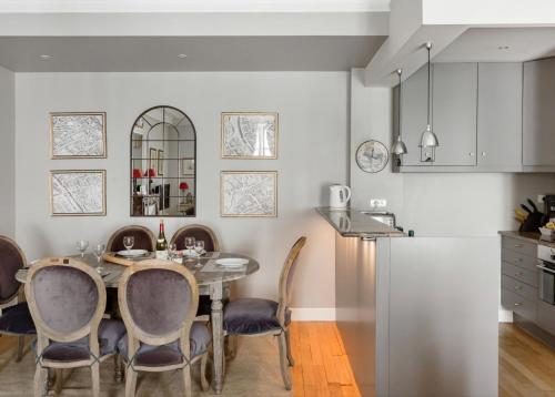 une cuisine et une salle à manger avec une table et des chaises dans l'établissement brouilly apartment one block from Eiffel Tower, à Paris