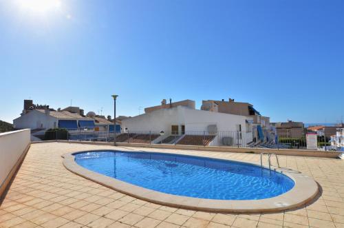 a swimming pool in the middle of a tiled yard at Penthouse with Panoramic View by NRAS in Santa Pola