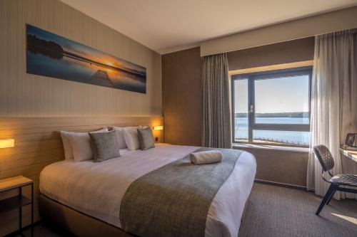 a hotel room with a bed and a large window at Golden Lakes Hotel in Boussu-lez-Walcourt
