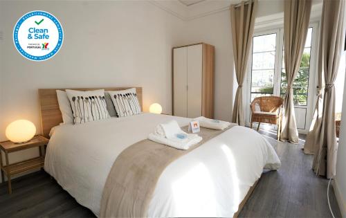 a bedroom with a large white bed with towels on it at Lisbon 7Rooms in Lisbon