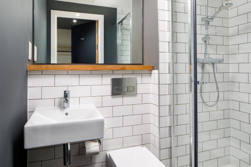 a white bathroom with a sink and a mirror at ibis Budget Sheffield Centre St Marys Gate in Sheffield