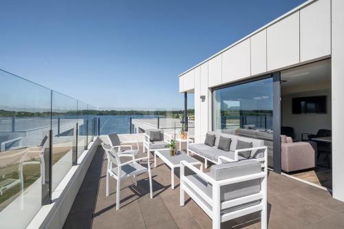 a balcony with white chairs and tables on a yacht at Golden Lakes Hotel in Boussu-lez-Walcourt
