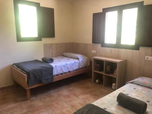 a bedroom with two beds and two windows at Casa de Campo Patricia in Priego de Córdoba