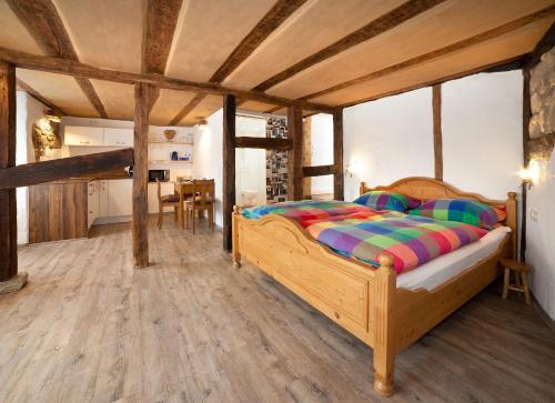 a bedroom with a wooden bed and a dining room at Beim Schloß Michel in Lauda-Königshofen