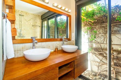 2 lavabos en un baño con un espejo grande en Corail - Villa de charme pieds dans l'eau à Saint-Gilles-les-Bains, en Saint-Gilles-les-Bains