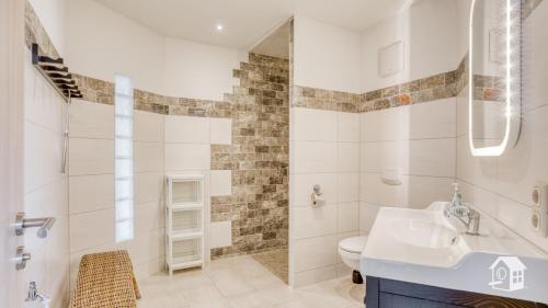 La salle de bains est pourvue d'un lavabo, de toilettes et d'une douche. dans l'établissement Ferienhaus mit Garten, Pool und Gastraum im Vogtland bis 25 Personen, à Heinsdorfergrund