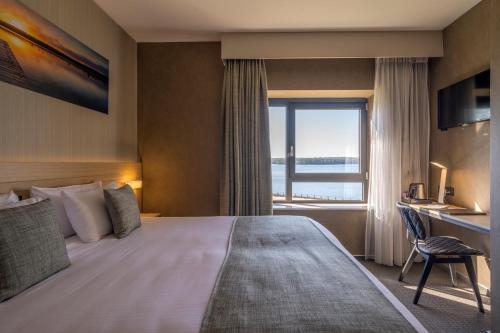 a hotel room with a large bed and a window at Golden Lakes Hotel in Boussu-lez-Walcourt