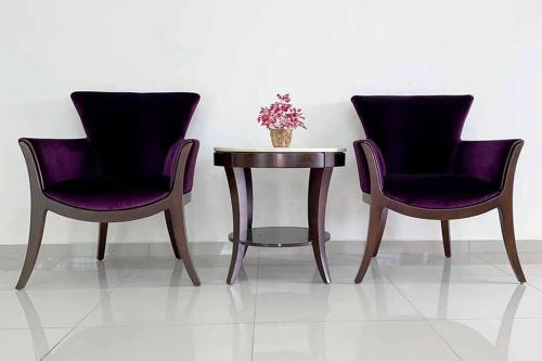 two chairs and a table with a vase of flowers at Umbai Homestay - Wak Sidin House in Melaka