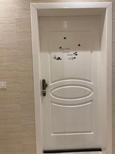 a white door with birds and words on it at A - 369 مقابل الراشد مول in Abha