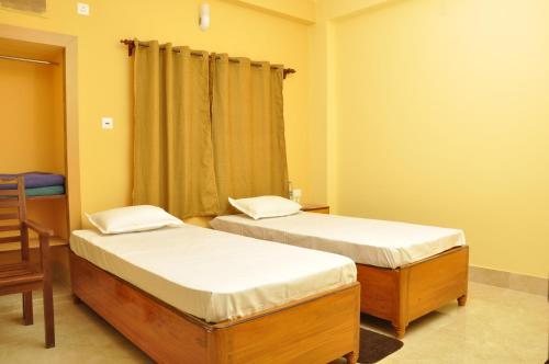 two twin beds in a room with a window at Solitary Nook in Gosāba