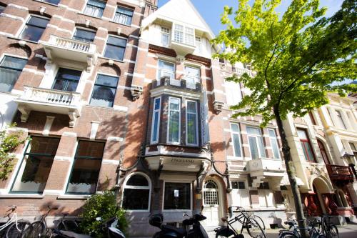 un edificio con bicicletas estacionadas frente a él en Quentin England Hotel, en Ámsterdam