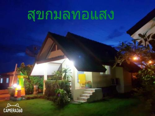 a house with lights on the side of it at night at สุขกมลรับอรุณแฝด2ห้อง in Chanthaburi