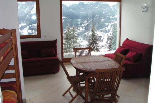 sala de estar con mesa, sillas y sofá en Studio 33m2 vue panoramique sur le Grand Massif et Mt Blanc, plein sud, en Verchaix