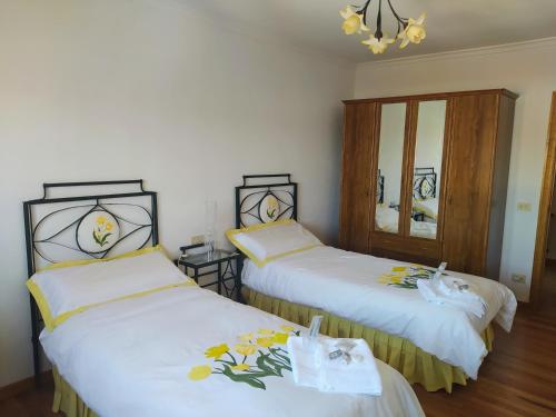 1 dormitorio con 2 camas con sábanas blancas y espejo en CASA MENCIA, en Sober