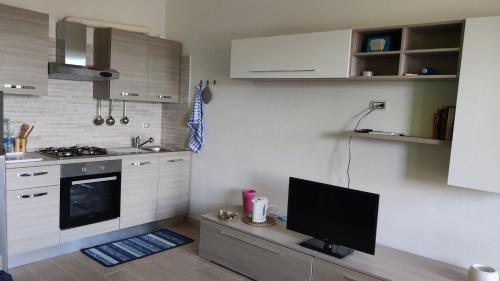 a kitchen with a flat screen tv on a table at Sa Dommu 'e su coro in Triei