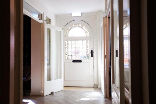 a hallway with a white door and a window at Quentin England Hotel in Amsterdam