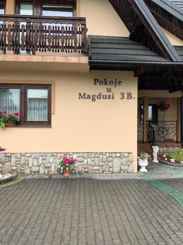 a sign on the side of a building at Pokoje u Magdusi przy termach in Witów