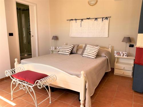 a bedroom with a large bed with a red stool at Appartamenti Sole 1 in Alghero