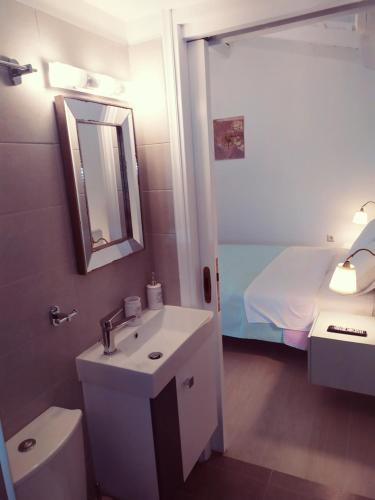 La salle de bains est pourvue d'un lavabo, de toilettes et d'un miroir. dans l'établissement Villa Anna, à Naupacte