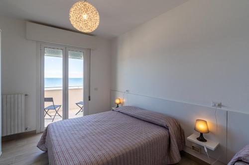 a bedroom with a bed and a view of the beach at Residenza Las Vegas in Bellaria-Igea Marina