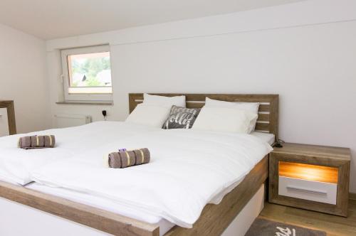 Un dormitorio con una gran cama blanca y una ventana. en Apartments Gozd Martuljek, en Kranjska Gora