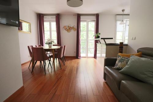 un salon avec un canapé, une table et des chaises dans l'établissement Family stay - steps from Disneyland, à Serris