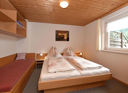 um quarto com uma cama e uma janela em Ferienwohnungen Schantl em Schoppernau