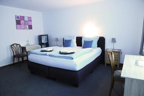 1 dormitorio con 1 cama grande con almohadas azules en Hotel Deutsches Haus en Cuxhaven