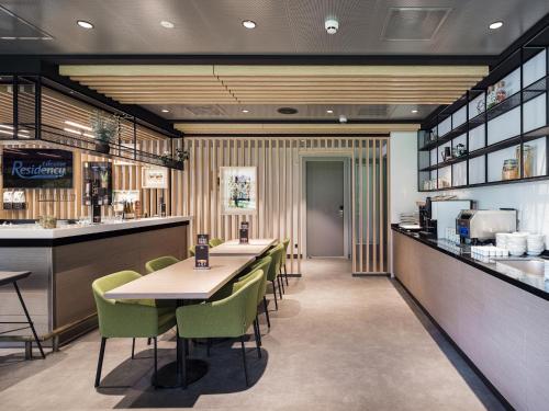 a restaurant with tables and chairs and a bar at Executive Residency by Best Western Amsterdam Airport in Hoofddorp