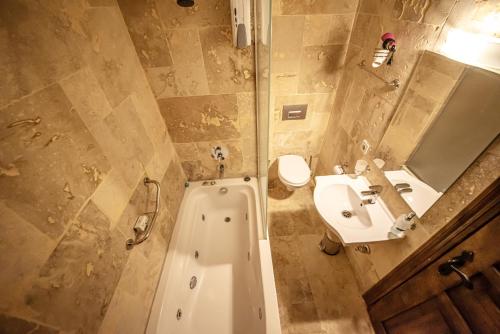 a bathroom with a tub and a sink and a toilet at Murat Pasha Mansion in Dalyan