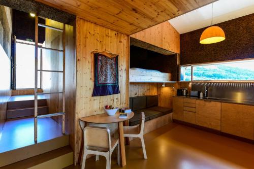 a kitchen with a table and chairs in a room at Vale do Ninho Nature Houses in Ferraria de São João