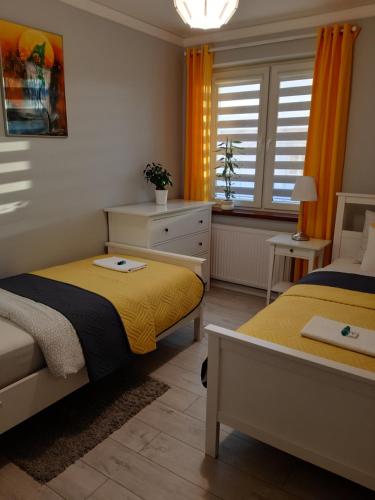 1 Schlafzimmer mit 2 Betten und einem Fenster in der Unterkunft Apartament FAMILY- klimatyzacja in Oświęcim