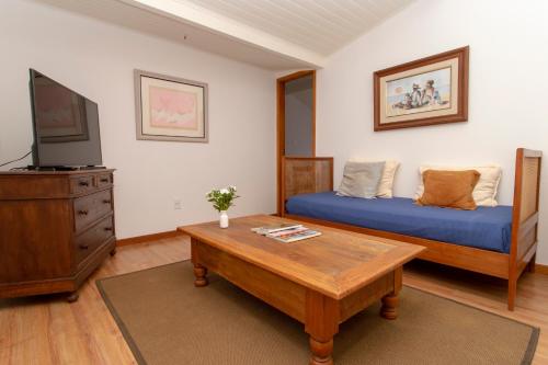uma sala de estar com uma cama e uma mesa de centro em Suites Caipira Vale das Videiras em Araras Petropolis