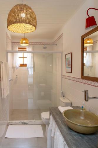 a bathroom with a sink and a shower and a toilet at Suites Caipira Vale das Videiras in Araras Petropolis