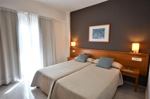 Cette chambre comprend 2 lits et une fenêtre. dans l'établissement Hostal Mallorca, à Sant Antoni de Portmany