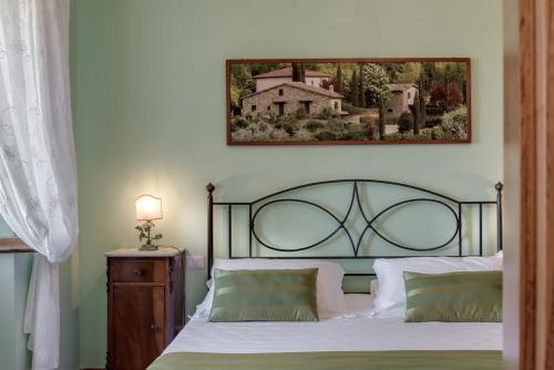 a bedroom with a bed and a picture on the wall at Castellinuzza in Greve in Chianti