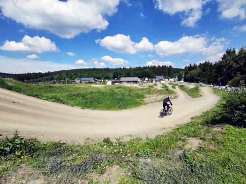 a person riding a bike on a dirt road at StayCozy Bike&Ski Apartments, barrierefrei, free WIFI, Erdgeschoss in Winterberg