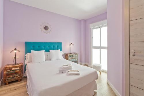 a bedroom with a large white bed with a blue headboard at Hostel SEA&DREAMS Calpe in Calpe