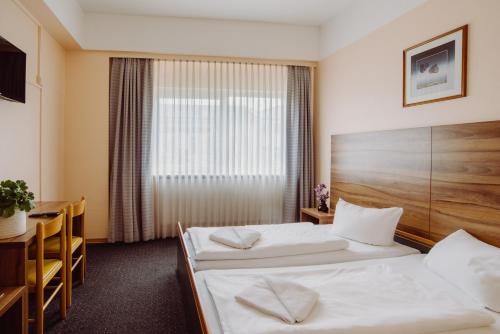 a hotel room with two beds and a table at Alper Hotel am Potsdamer Platz in Berlin