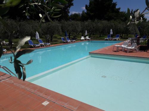 a large blue swimming pool with chairs and chairs at Villa Nottola in Montepulciano