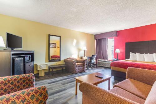 a hotel room with a bed and a living room at Econo Lodge & Suites Clarksville in Clarksville
