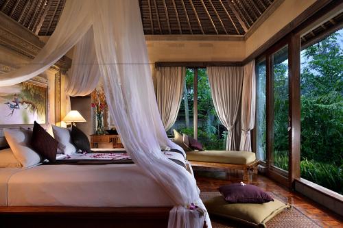 1 dormitorio con 1 cama con mosquitera en The Royal Pita Maha, en Ubud