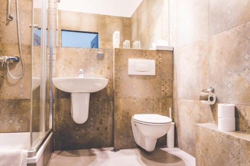 ein Bad mit einem WC, einem Waschbecken und einer Dusche in der Unterkunft Hotel Floryan Old Town in Krakau