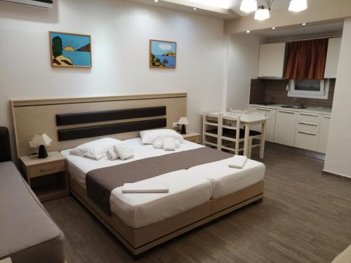 a bedroom with a large bed and a kitchen at Hotel Katerina in Keramotí